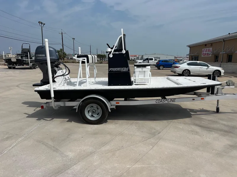 Slide: The Image of 2024 Freedom 14 Chiquita boat on trailer, featuring Yamaha engine, parked outdoors. - 19