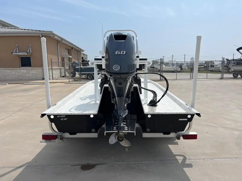 Slide: The Image of 2024 Freedom 14 CHIQUITA boat with 60 HP outboard motor, parked outdoors. - 21