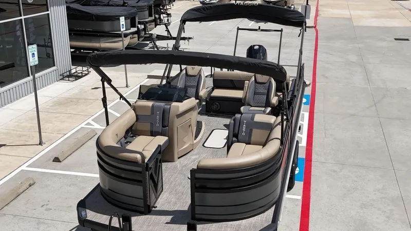 Slide: The Image of 2024 Viaggio Z22S pontoon boat with beige seating and black canopy in a parking lot. - 21