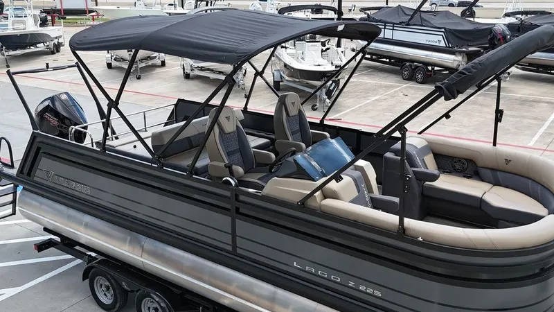 Slide: The Image of 2024 Viaggio Z22S pontoon boat with canopy, parked on a trailer in a marina. - 32