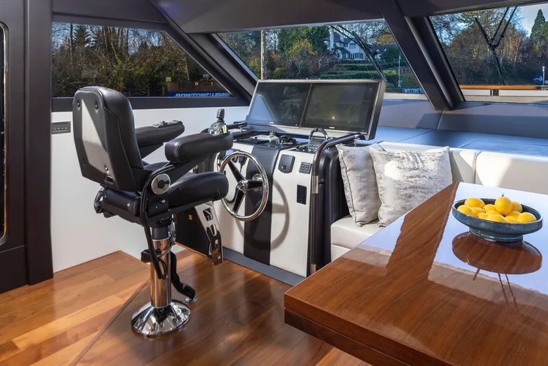 Slide: The Image of Luxurious helm of 2020 Ocean Alexander 70E Motoryacht with plush seating and modern controls. - 16