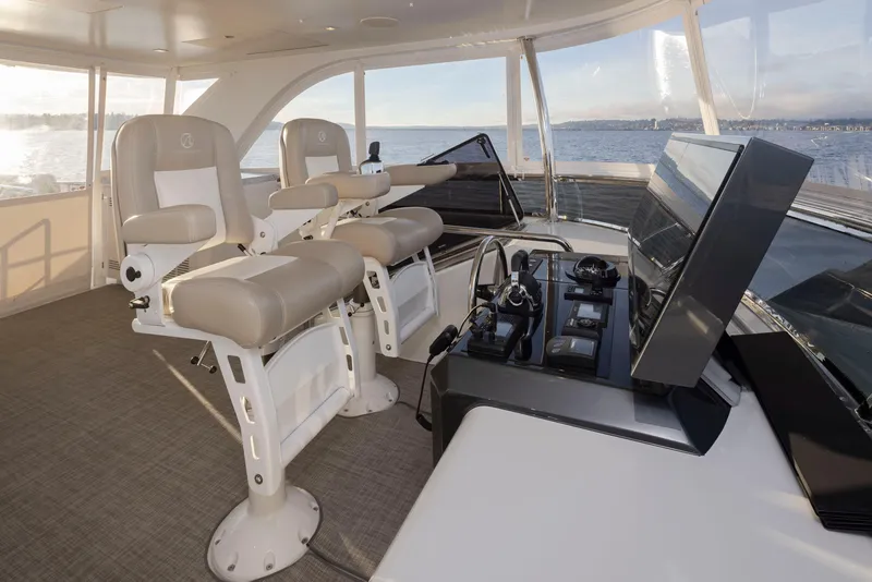 Slide: The Image of Luxurious helm of 2020 Ocean Alexander 70E Motoryacht with dual captain chairs and navigation controls. - 31