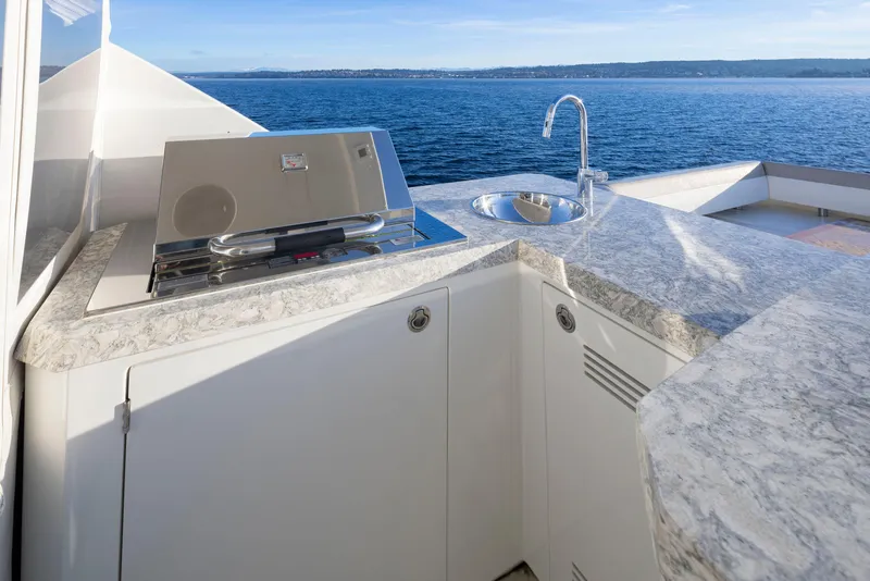 Slide: The Image of Outdoor kitchen on 2020 Ocean Alexander 70E Motoryacht with grill and sink, overlooking the ocean. - 34