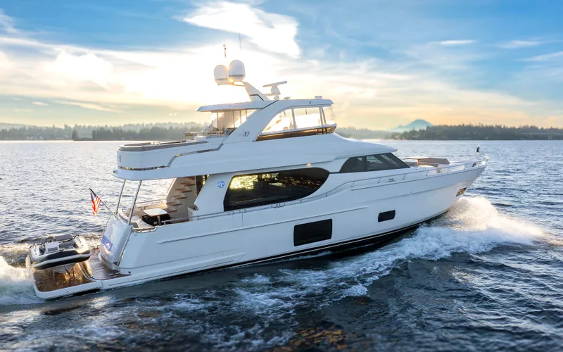 Slide: The Image of 2020 Ocean Alexander 70E Motoryacht cruising on open water at sunset. - 9