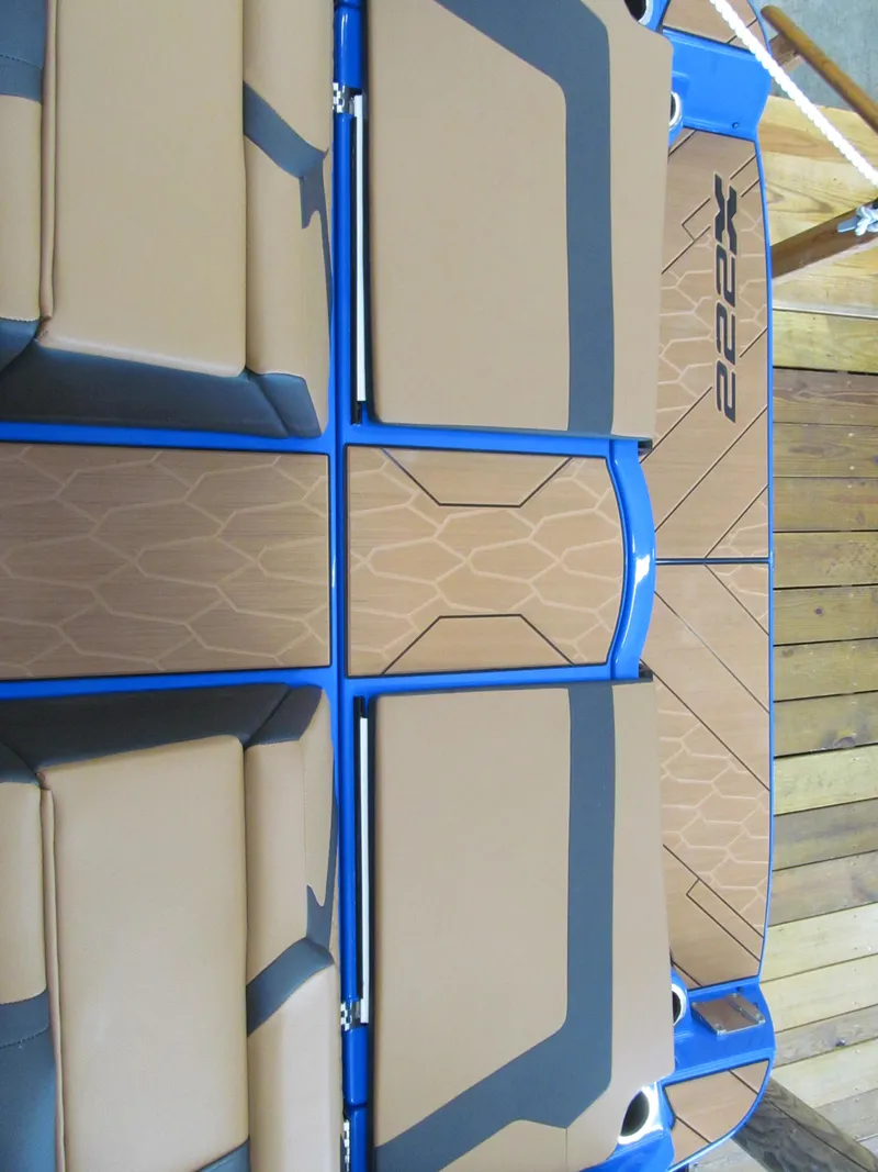 Slide: The Image of 2025 Yamaha Boats 222XD deck with brown and blue design, featuring cushioned seating. - 10