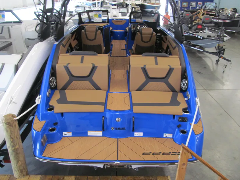 Slide: The Image of 2025 Yamaha Boats 222XD, blue exterior, spacious seating, modern design, displayed indoors. - 3
