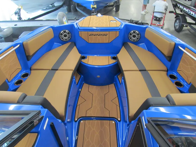 Slide: The Image of 2025 Yamaha Boats 222XD interior with blue and tan seating, speakers, and cup holders. - 7