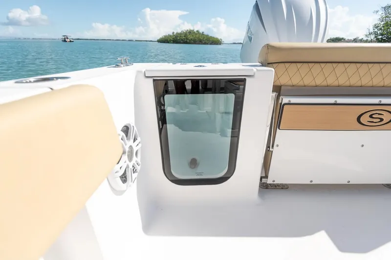 Slide: The Image of 2025 Sportsman Open 232 Center Console boat interior with seating and storage, on a sunny day. - 5