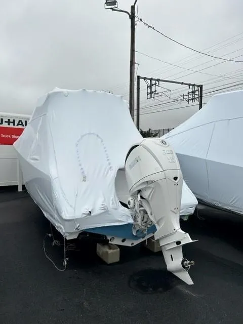 Slide: The Image of 2025 Sportsman Open 232 Center Console boat, covered, with outboard motor, in storage. - 7