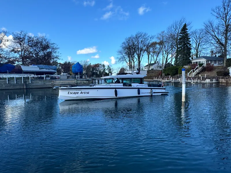 Slide: The Image of 2020 Axopar 37 Cross Cabin BRABUS docked, named "Escape Artist," under a partly cloudy sky. - 3