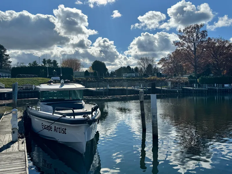 Slide: The Image of Axopar 37 Cross Cabin BRABUS 2020 docked at a serene waterfront with houses in the background. - 6