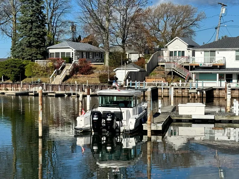 Slide: The Image of 2020 Axopar 37 Cross Cabin BRABUS docked by a lakeside house in a serene setting. - 7