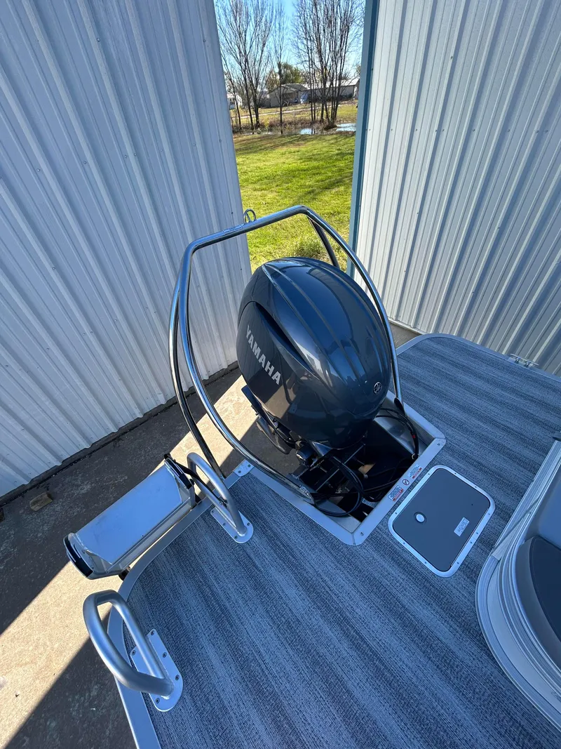 Slide: The Image of 2025 Bennington S 22 boat with Yamaha outboard motor, docked near metal building. - 10