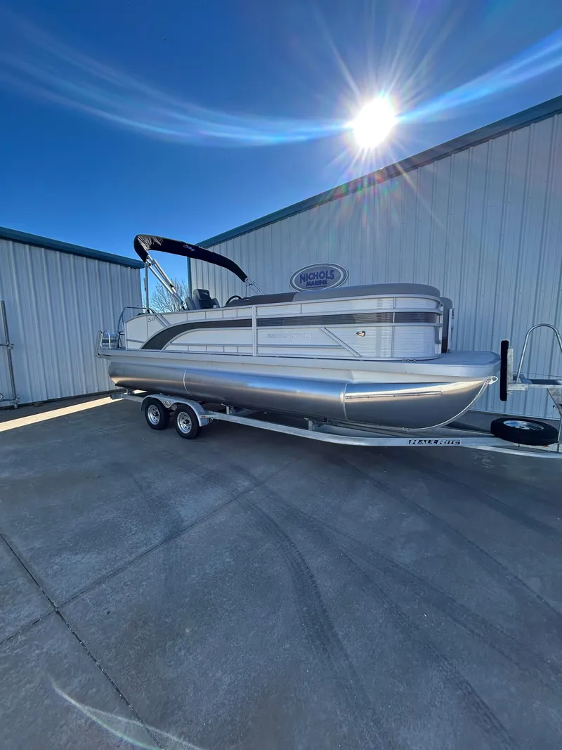 Slide: The Image of 2025 Bennington S 22 pontoon boat on trailer under bright sun. - 3