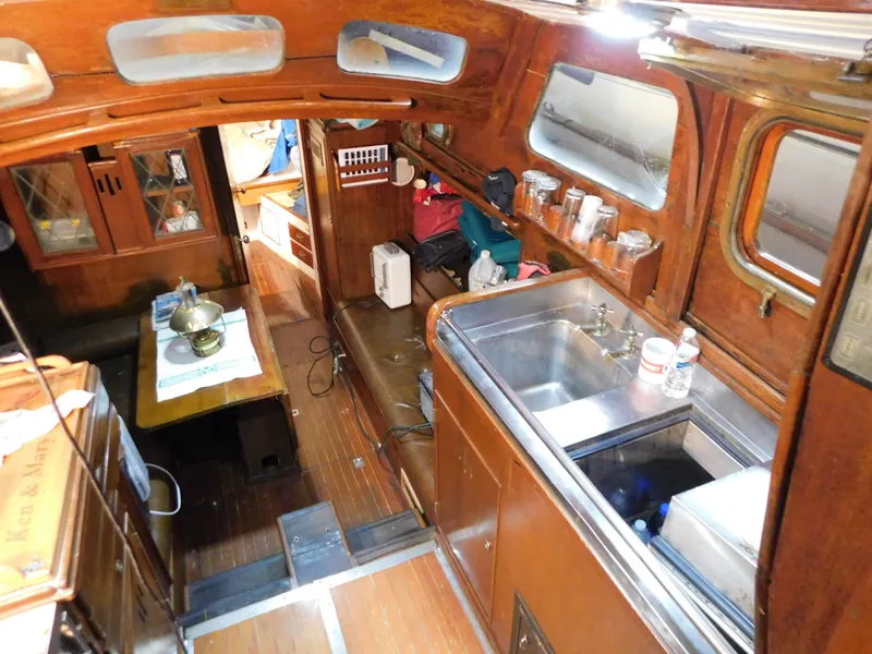 Slide: The Image of Interior of 1949 Burger Full Keel Steel Auxiliary Ketch with wooden cabinetry and compact kitchen. - 21