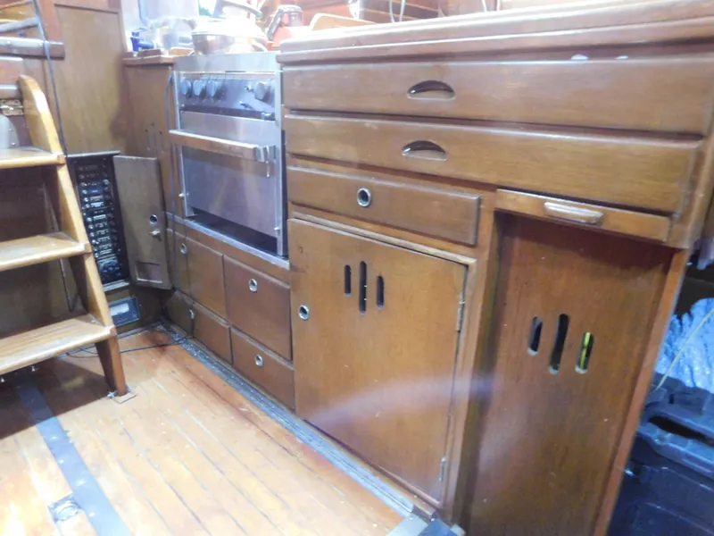Slide: The Image of Wooden galley interior of 1949 Burger Full Keel Steel Auxiliary Ketch with stove and storage. - 23