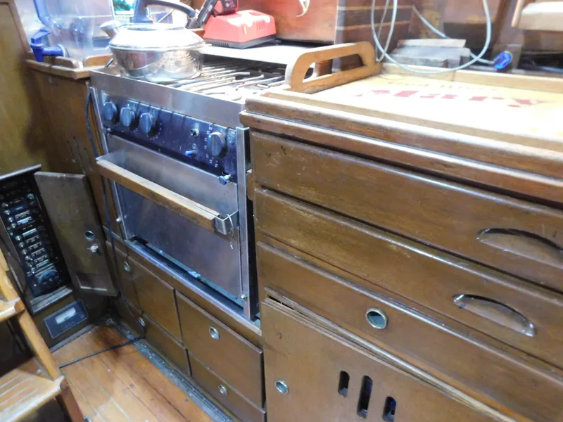 Slide: The Image of Vintage 1949 Burger Full Keel Steel Auxiliary Ketch galley with stove and wooden cabinetry. - 24