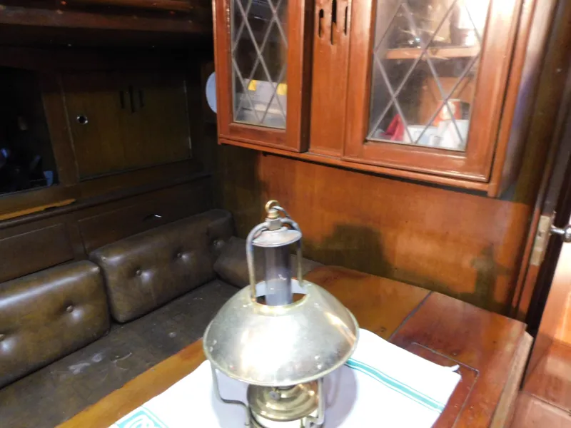 Slide: The Image of Interior of 1949 Burger Full Keel Steel Auxiliary Ketch with vintage lamp and wooden cabinetry. - 28