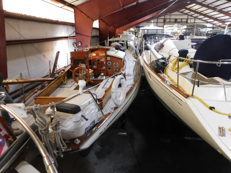 Slide: The Image of 1949 Burger Full Keel Steel Auxiliary Ketch in indoor storage, alongside other boats. - 6