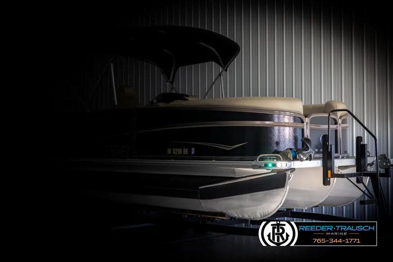Slide: The Image of 2022 Premier 210 Sunsation pontoon boat in dimly lit storage facility. - 4