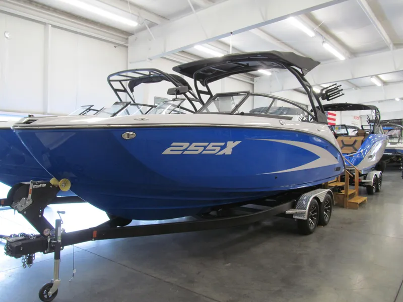 Slide: The Image of 2025 Yamaha Boats 255XD in showroom, blue exterior, on trailer. - 1