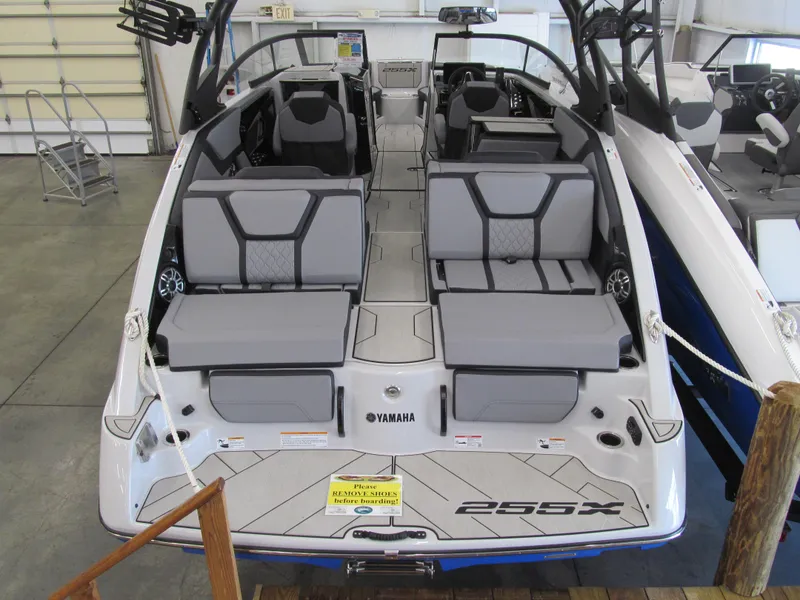 Slide: The Image of 2025 Yamaha Boats 255XD interior with gray seating, showcased in a showroom. - 3