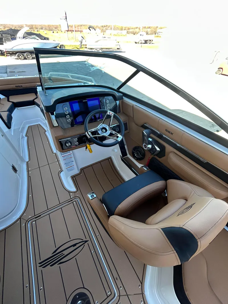 Slide: The Image of 2025 Chaparral 267 SSX boat interior with modern dashboard and tan seating. - 6