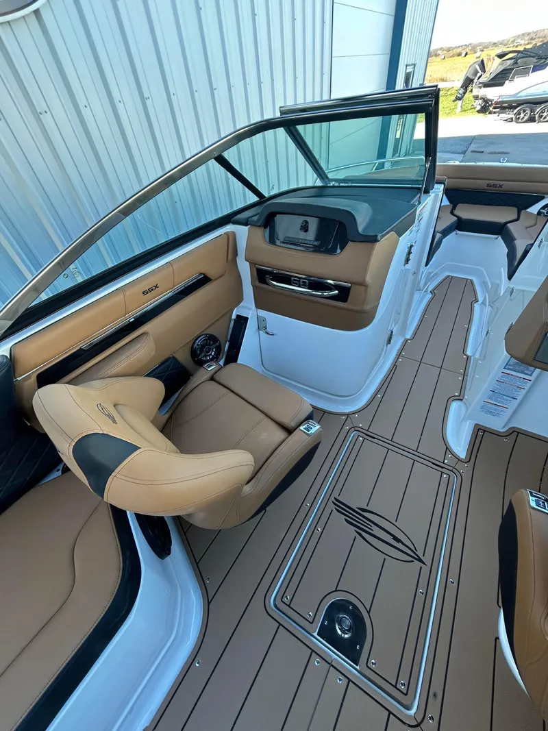 Slide: The Image of 2025 Chaparral 267 SSX boat interior with tan seating and sleek dashboard design. - 7