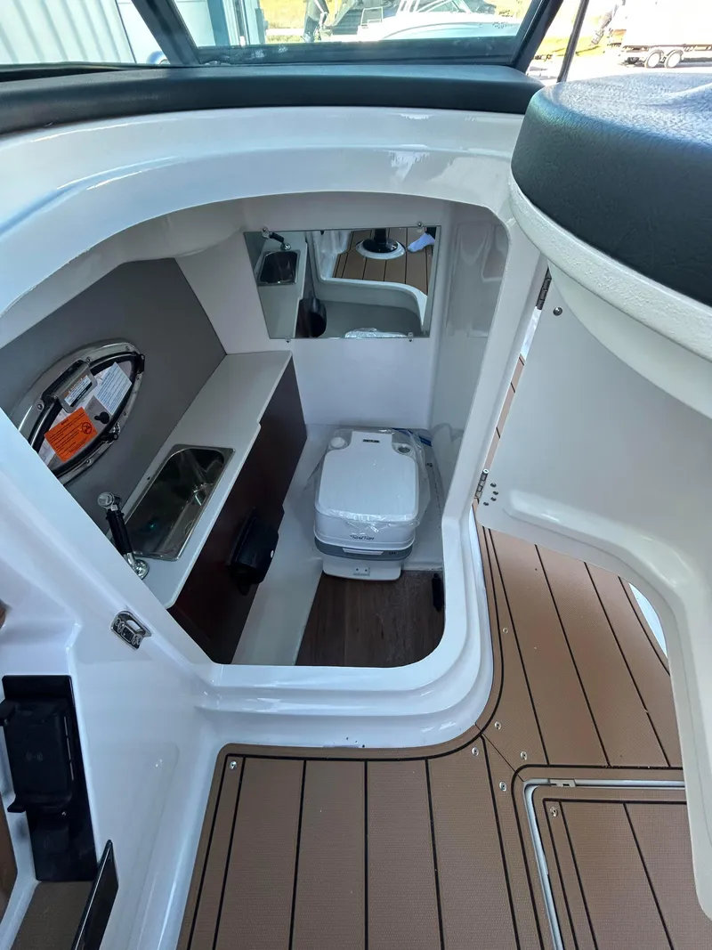 Slide: The Image of 2025 Chaparral 267 SSX boat interior with compact bathroom and modern amenities. - 8