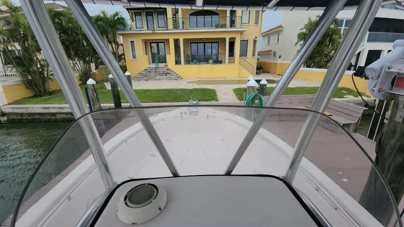 Slide: The Image of 2008 Grady-White Advance 257 boat docked near a yellow waterfront house. - 43