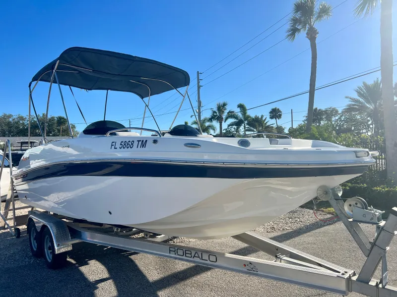 Slide: The Image of 2023 Hurricane 218 SS boat on trailer with canopy, parked outdoors. - 1