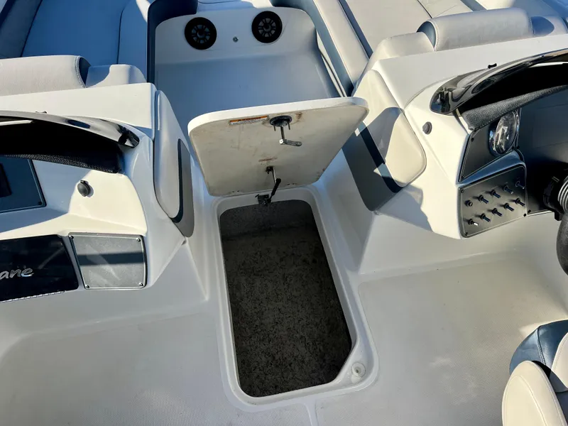 Slide: The Image of 2023 Hurricane 218 SS boat interior with open storage compartment and seating area. - 19