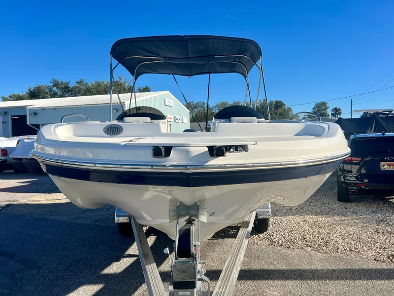 Slide: The Image of 2023 Hurricane 218 SS boat on trailer, parked outdoors under clear blue sky. - 2