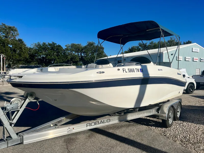 Slide: The Image of 2023 Hurricane 218 SS boat on trailer, parked outdoors under clear blue sky. - 3