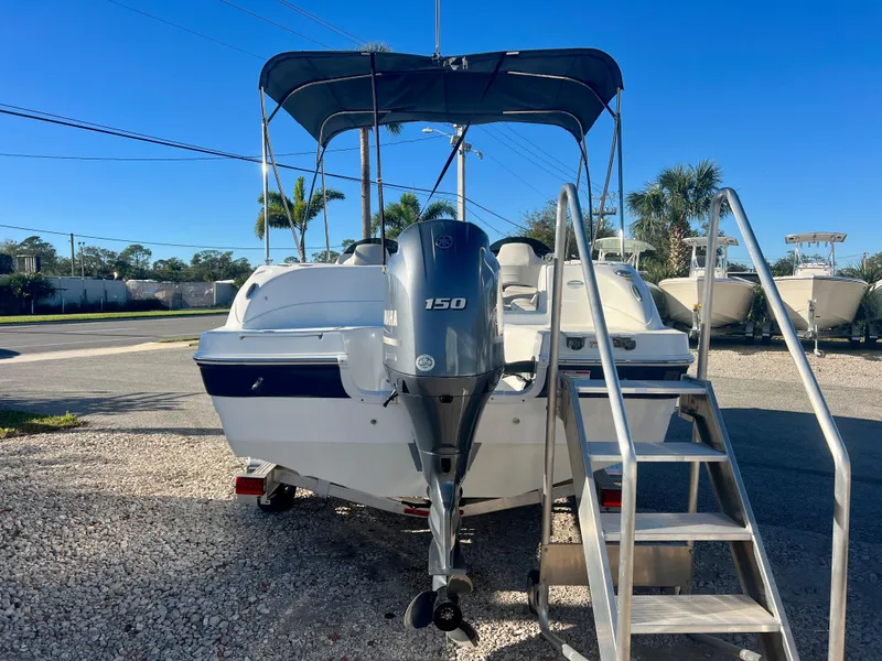 Slide: The Image of 2023 Hurricane 218 SS boat with Yamaha 150 engine, parked outdoors. - 6