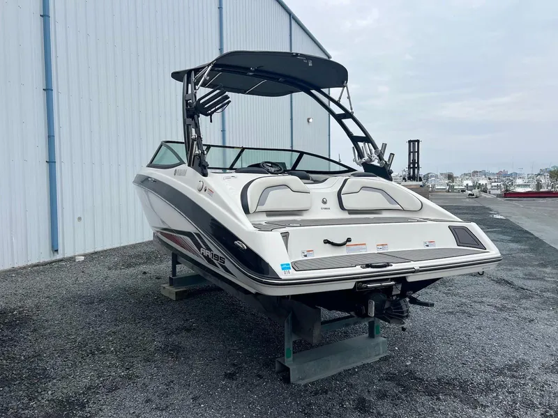 Slide: The Image of 2017 Yamaha AR195 boat on display near a warehouse. - 2