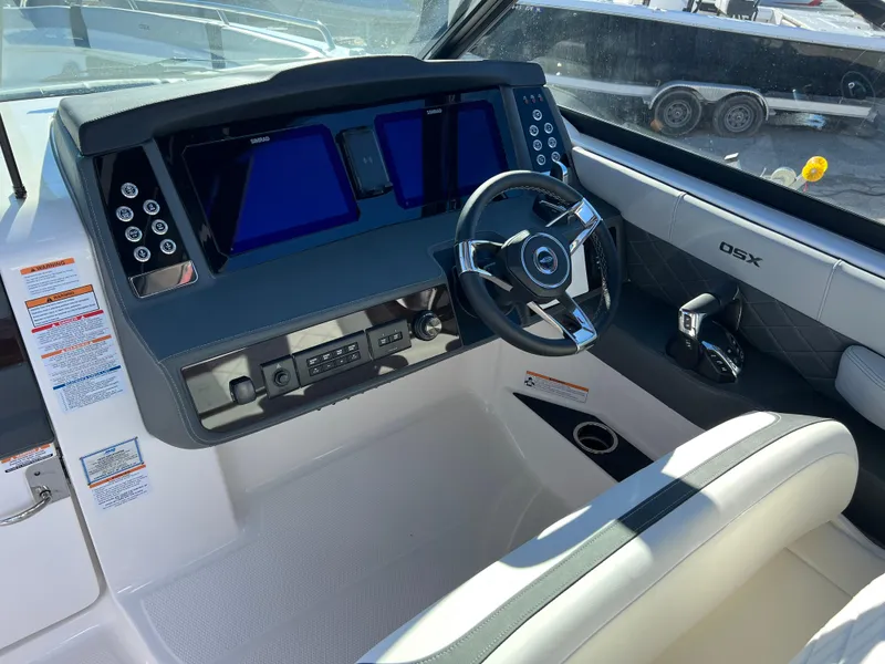 Slide: The Image of 2025 Chaparral 310 OSX boat cockpit with modern steering and dual displays. - 10