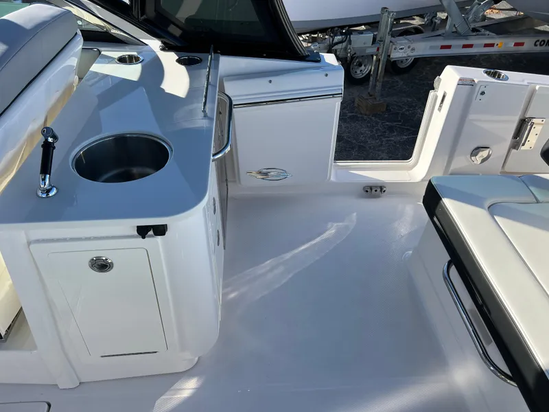 Slide: The Image of 2025 Chaparral 310 OSX boat interior with sink and seating area. - 23
