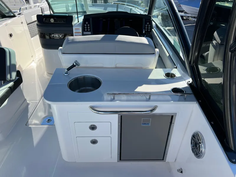 Slide: The Image of 2025 Chaparral 310 OSX boat interior with kitchenette and seating area. - 8