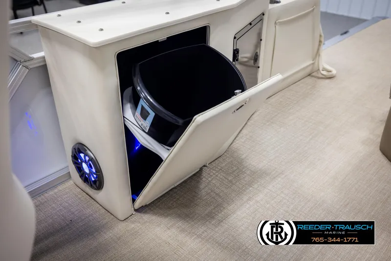 Slide: The Image of 2025 Avalon LSZ CRB boat interior with storage compartment and speaker, featuring beige upholstery. - 25