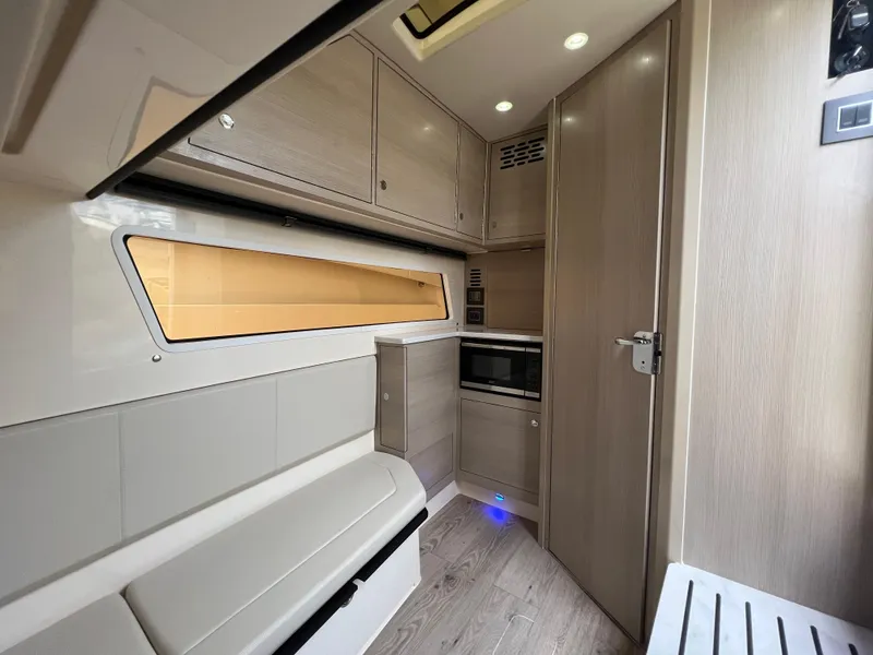 Slide: The Image of 2025 Scout 377 LXF interior with modern cabinetry, seating, and built-in microwave. - 22