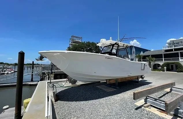 Slide: The Image of 2021 Sea Fox 328 Commander boat on dry dock under clear blue sky. - 1