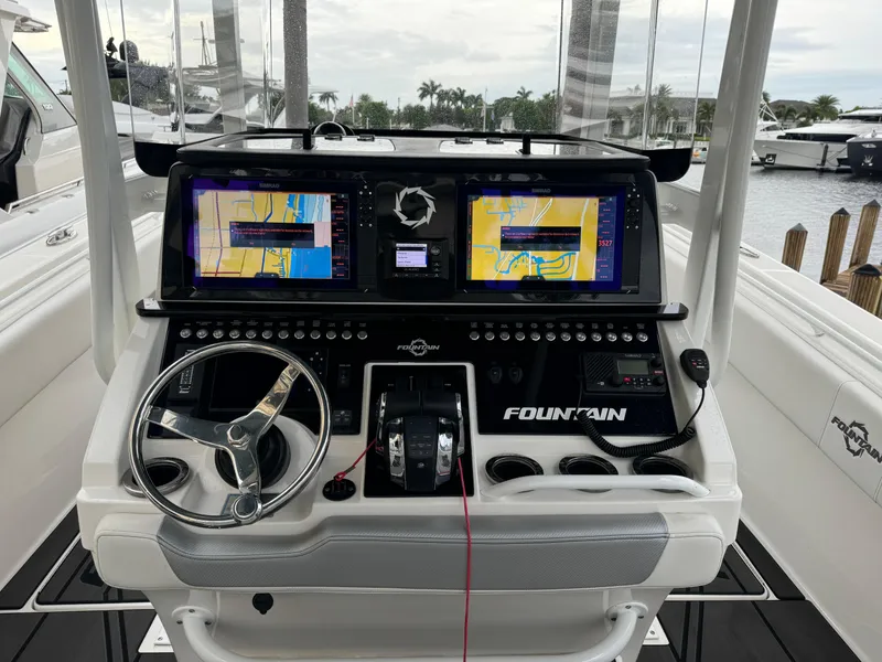 Slide: The Image of 2019 Fountain 38 CC boat dashboard with dual navigation screens and steering wheel. - 15