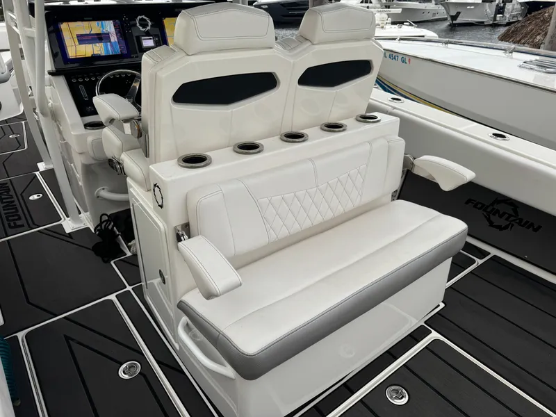 Slide: The Image of 2019 Fountain 38 CC boat interior with white seating and cup holders. - 18
