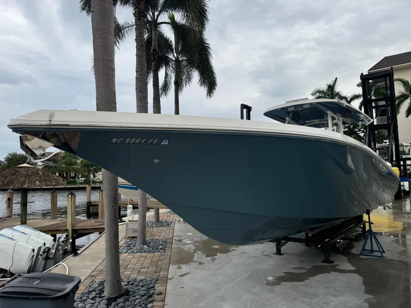 Slide: The Image of 2019 Fountain 38 CC boat docked near palm trees, overcast sky. - 3