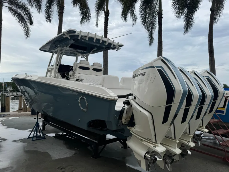 Slide: The Image of 2019 Fountain 38 CC boat with multiple engines, docked under palm trees. - 30