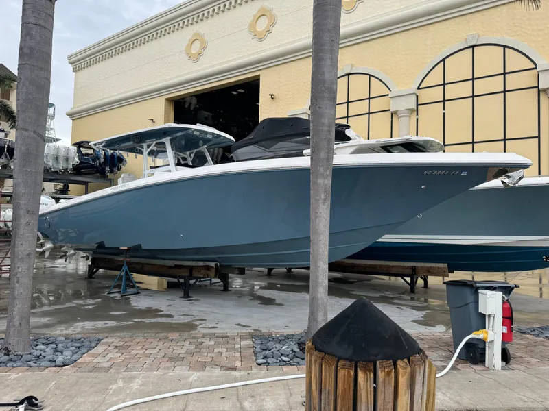 Slide: The Image of 2019 Fountain 38 CC boat in dry dock, blue hull, marina setting. - 4