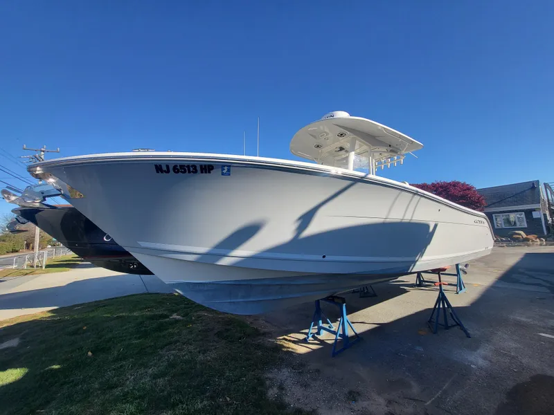Slide: The Image of 2021 Cobia 280 Center Console boat on stands, clear sky background. - 12