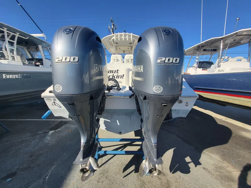Slide: The Image of 2021 Cobia 280 Center Console with twin Yamaha 200 engines, docked in a marina. - 13