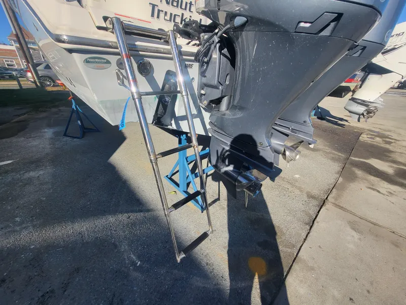 Slide: The Image of Cobia 280 Center Console 2021 boat with ladder and outboard motor in a marina. - 15